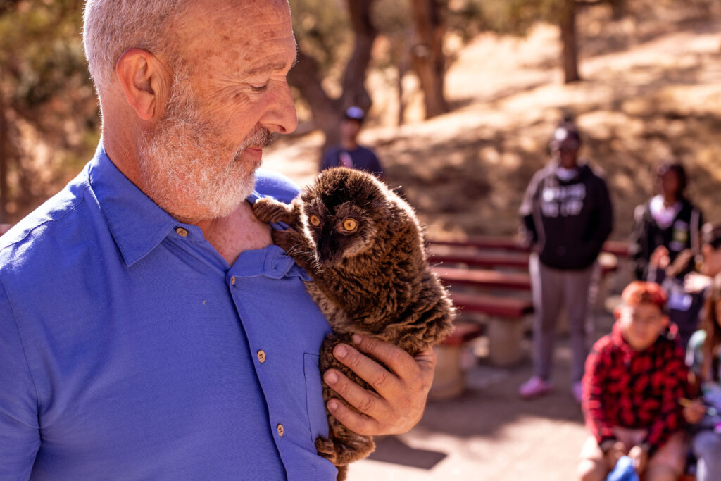 man holding lemur at camp fjc